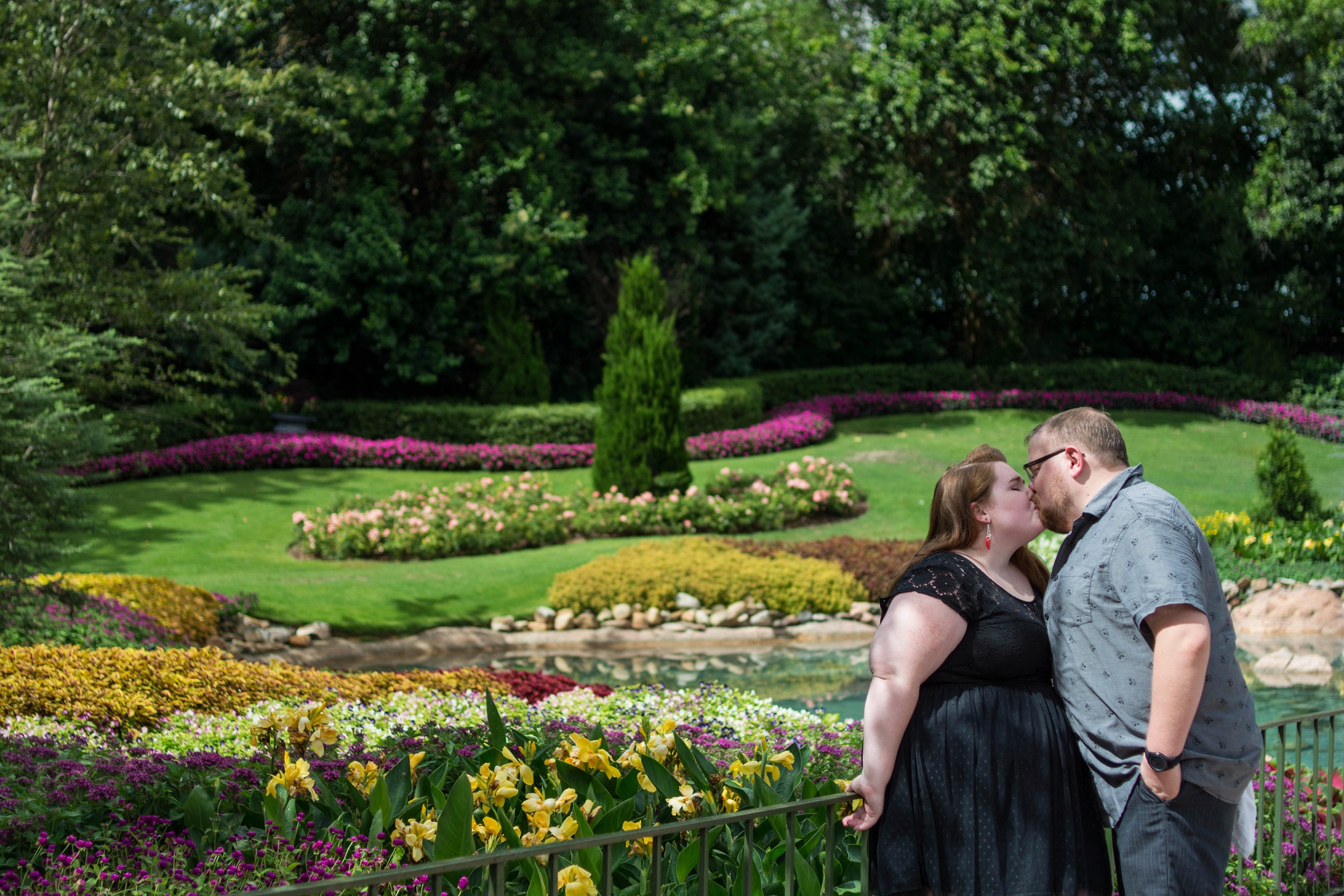 Engagement photos of couple standing in the vibrant colored gardens of the Canada pavillion at EPCOT