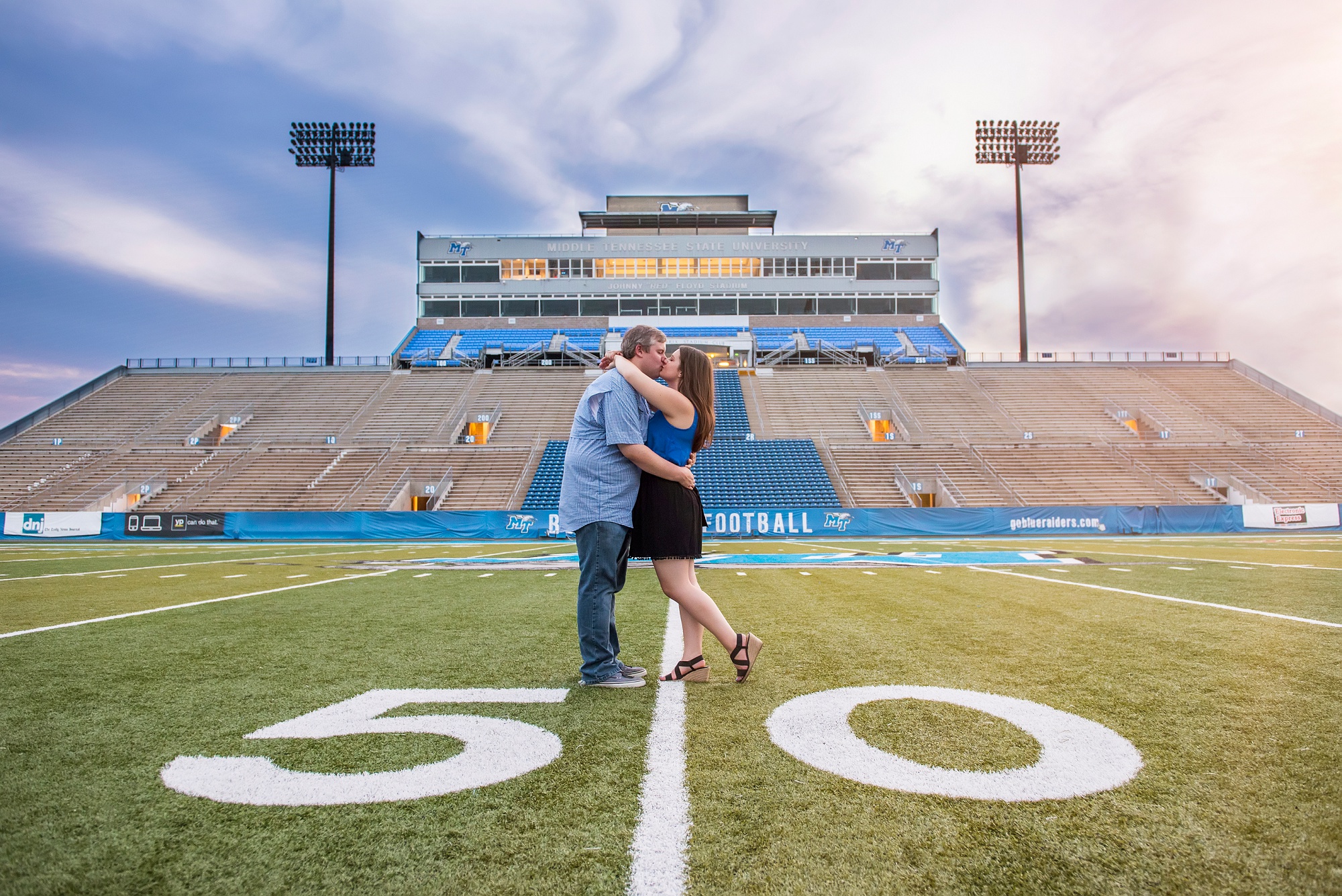 Couple kissing on 50 yard line of MTSU football field