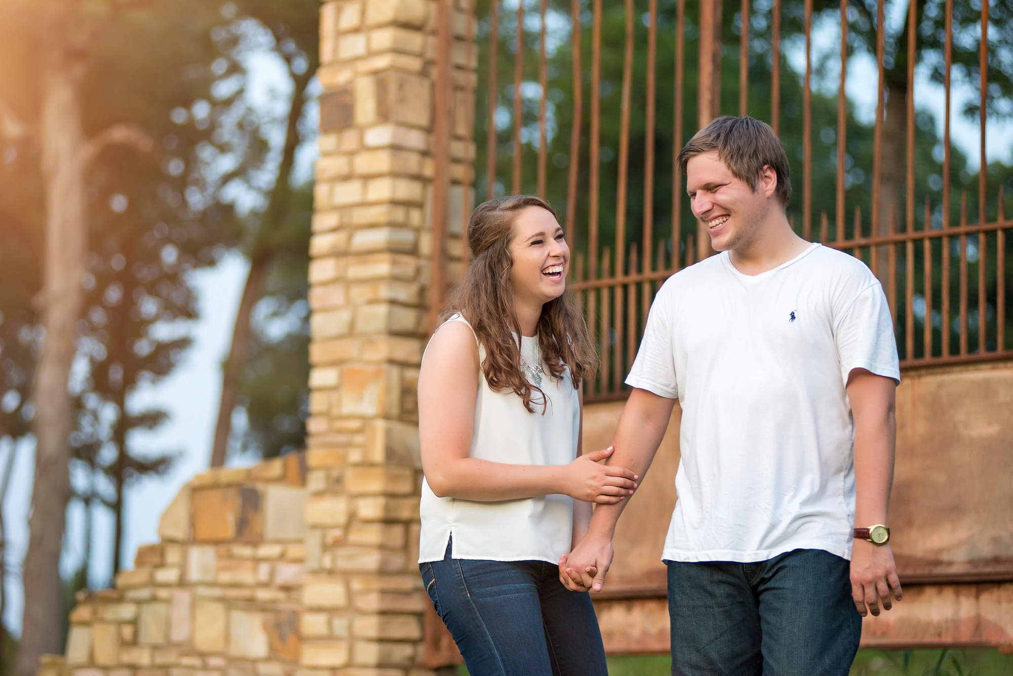 Joyful photo of engaged couple holding hands and laughing at Stone Gate Farm
