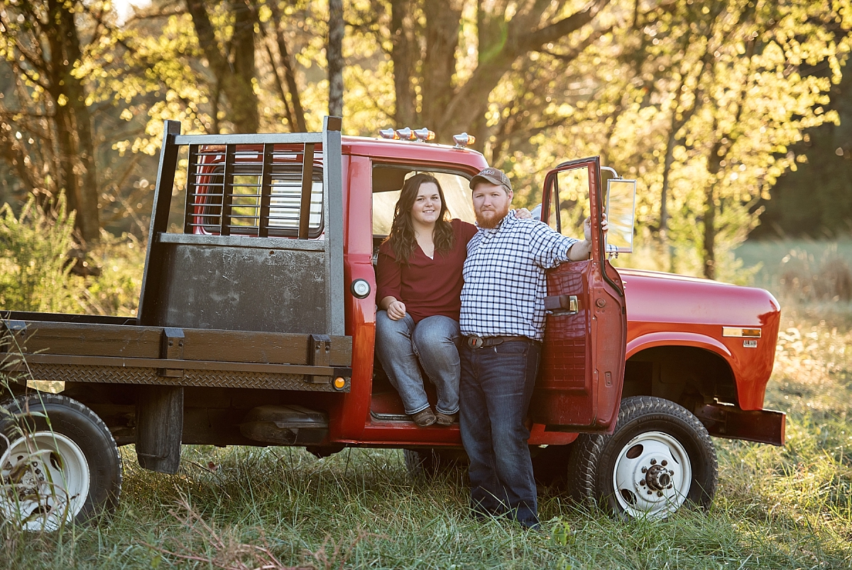 Engaged couple sitting in vintage red truck