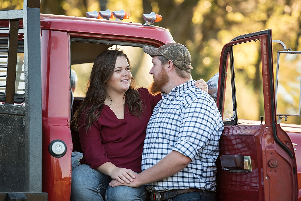 Couple sitting in vintage red truck for engagement pictures