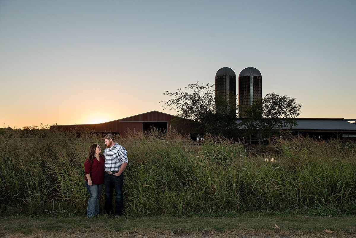 Family farm engagement photos with sun setting behind couple