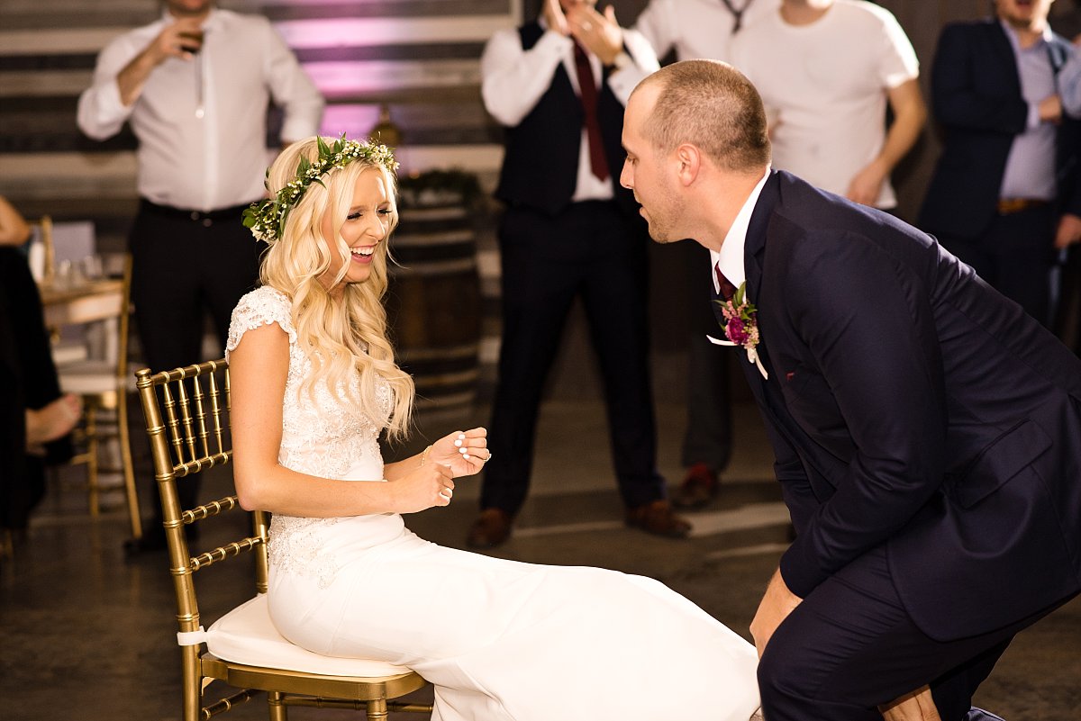 Bride laughing at her husband during garter toss