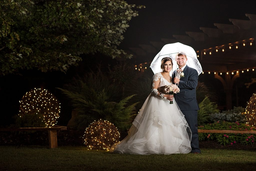 Night photos of bride and groom under umbrella with twinkle lights around them