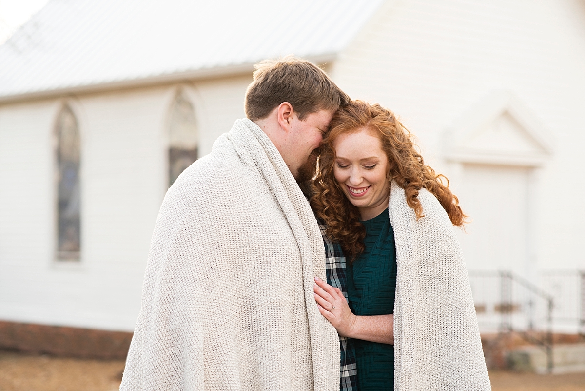 Murfeesboro engagement pictures of couple snuggling under blanket
