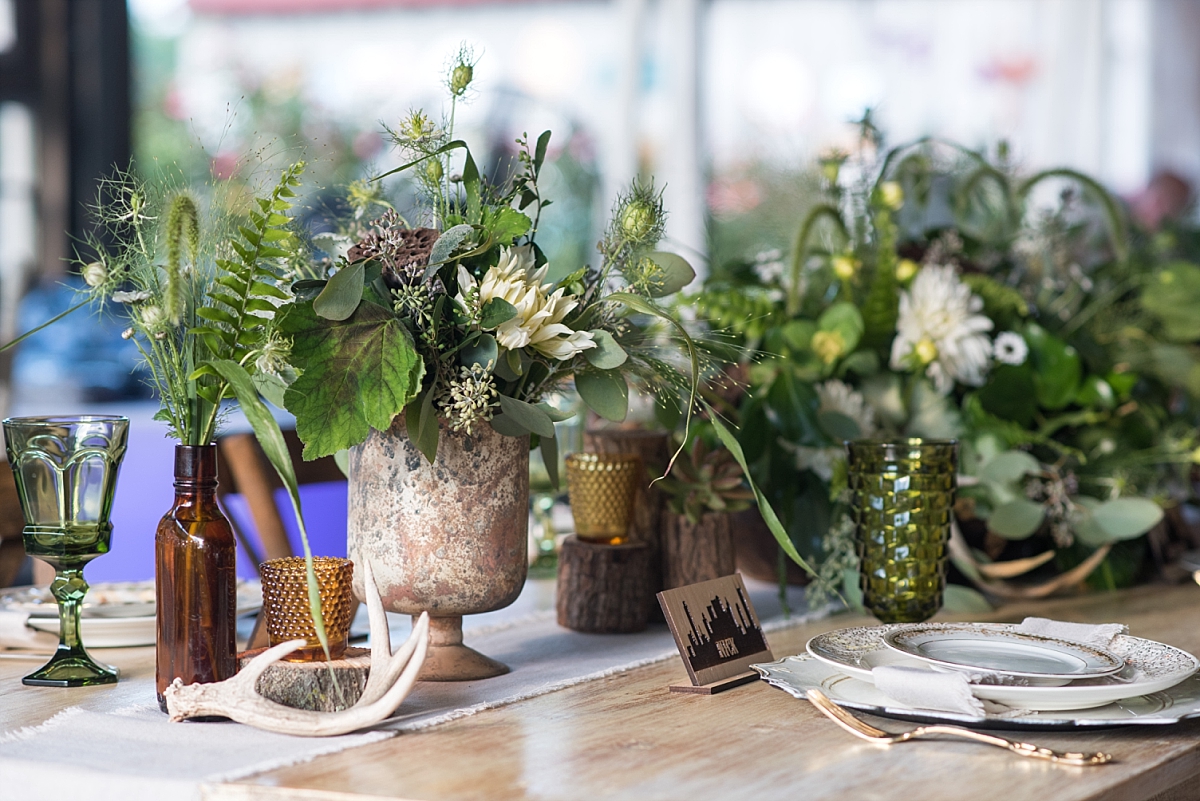 Large table arrangement of greenery and white flowers