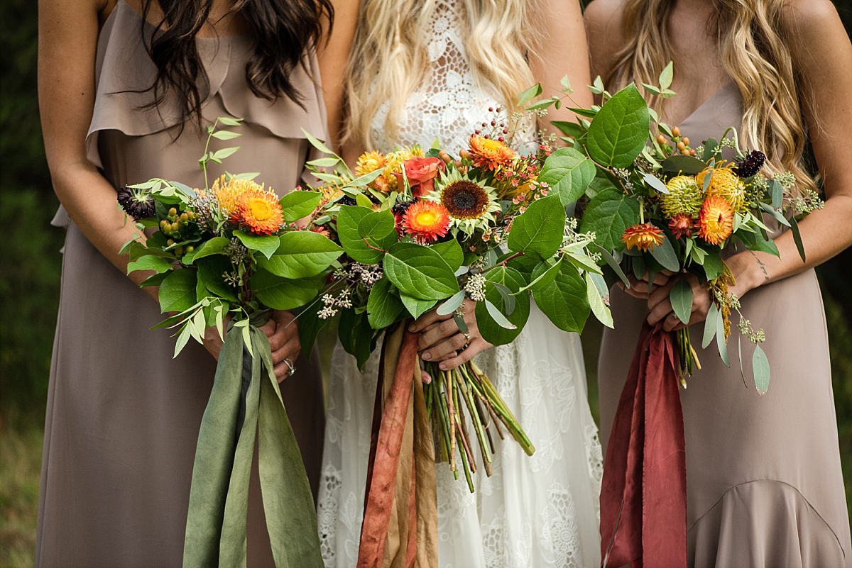 Fall bride and bridesmaid floral bouquets arrangements of flowers orange, yellow and green sunflowers. Process Workshop at Cedarwood Weddings Venue in Nashville TN
